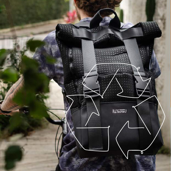 Um homem com camiseta xadrez e cabelos castanhos, andando de bicicleta usando uma mochila preta. Por cima da imagem, um desenho de reciclagem.